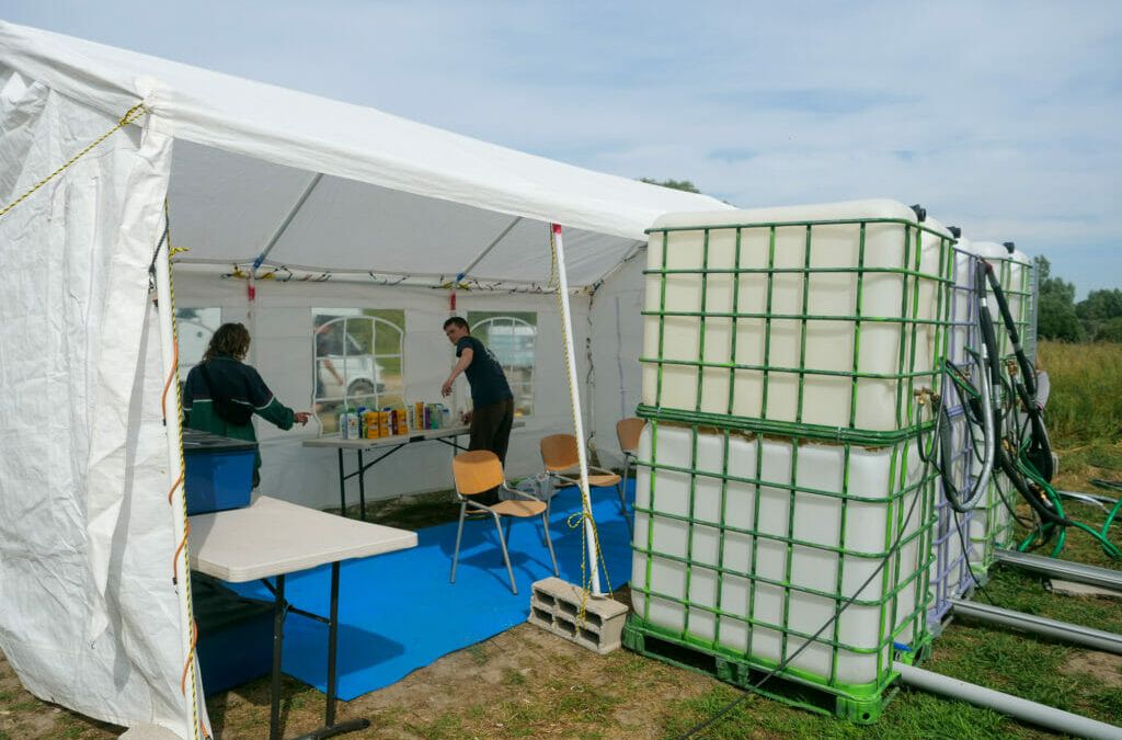 Freiwillige von Mobile Refugee Support (MRS) bauen mobile Duschen auf und bieten Handy-Ladestationen an.