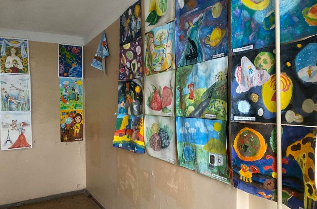 Ein Raum voller Gemälde an der Wand.