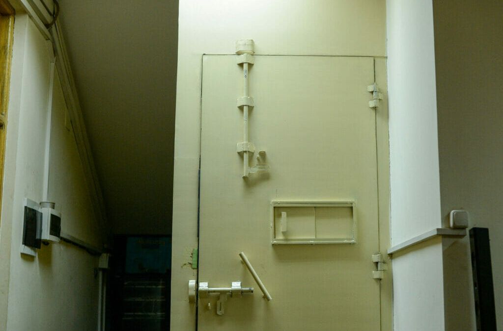 Stahltür mit großen Riegeln und Fenster zum Aufschieben.